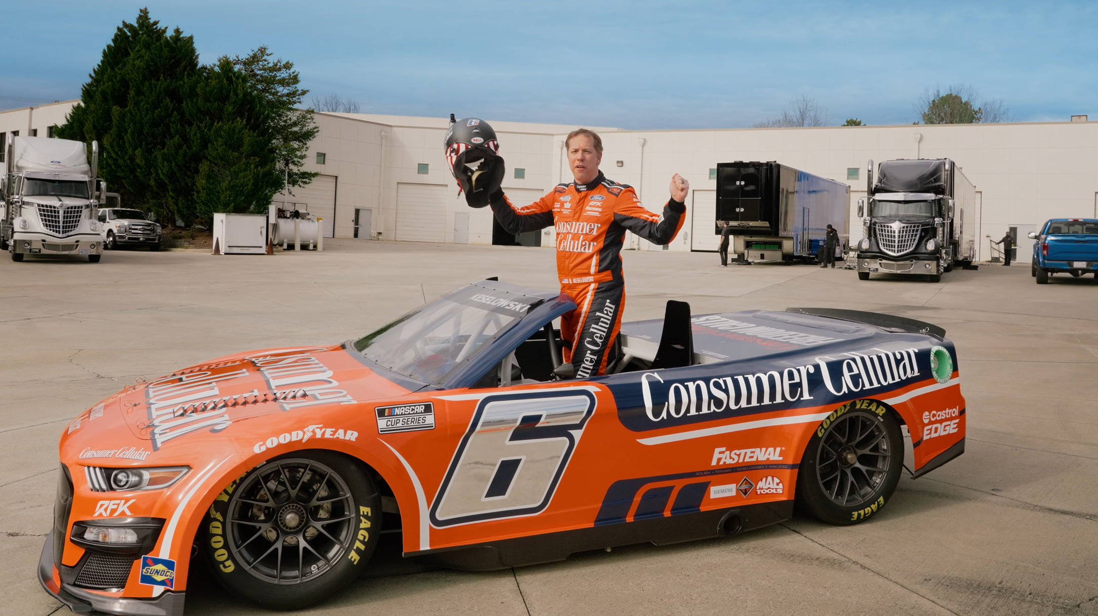 Driver standing up in convertible race car with top down